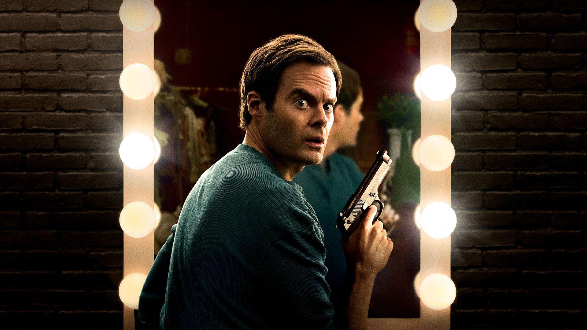 Bill Hader holding a handgun in front of a lit mirror in a still from HBO Max's 'Barry.'